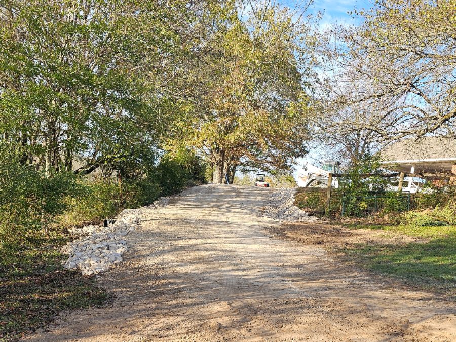 Finished gravel driveway with rock-lined drainage
