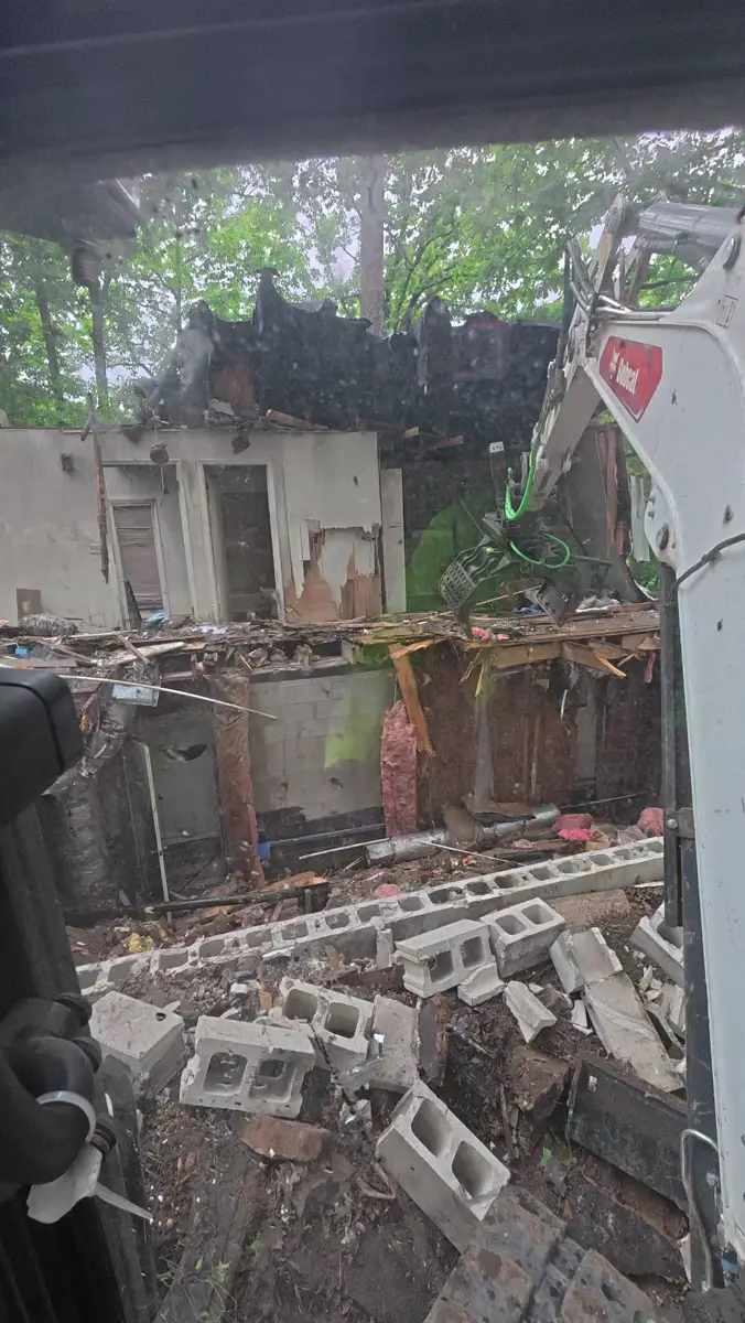 Excavator tearing down a house