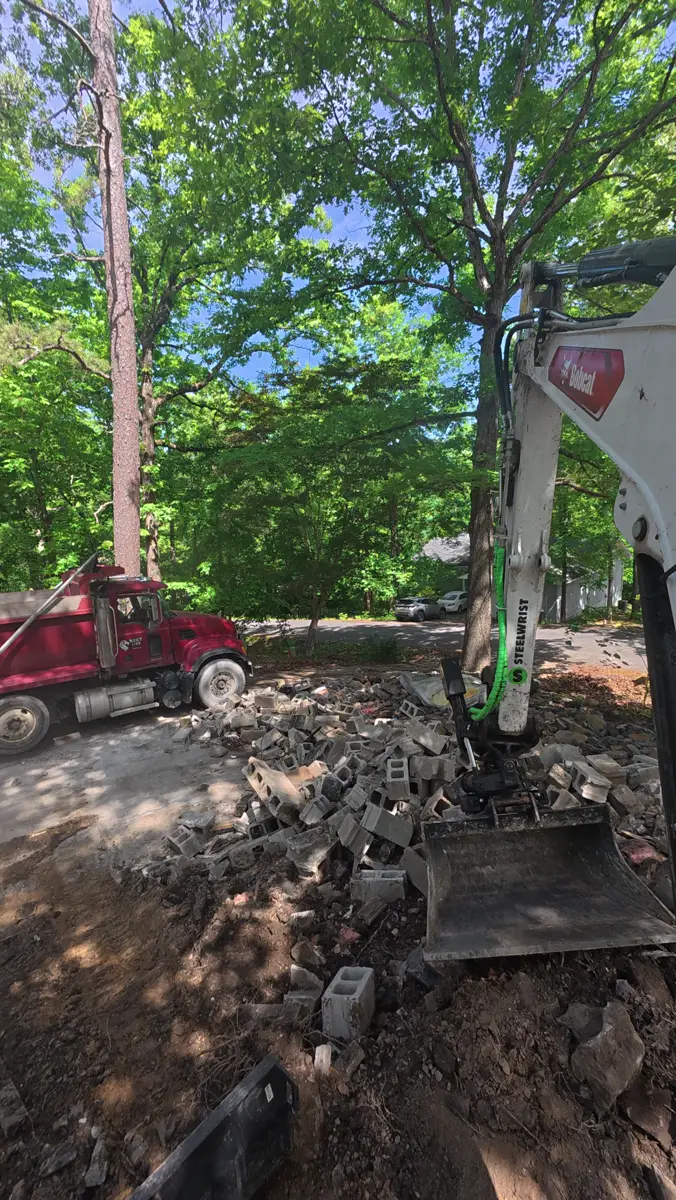 Concrete block and debris loaded beside a dump truck